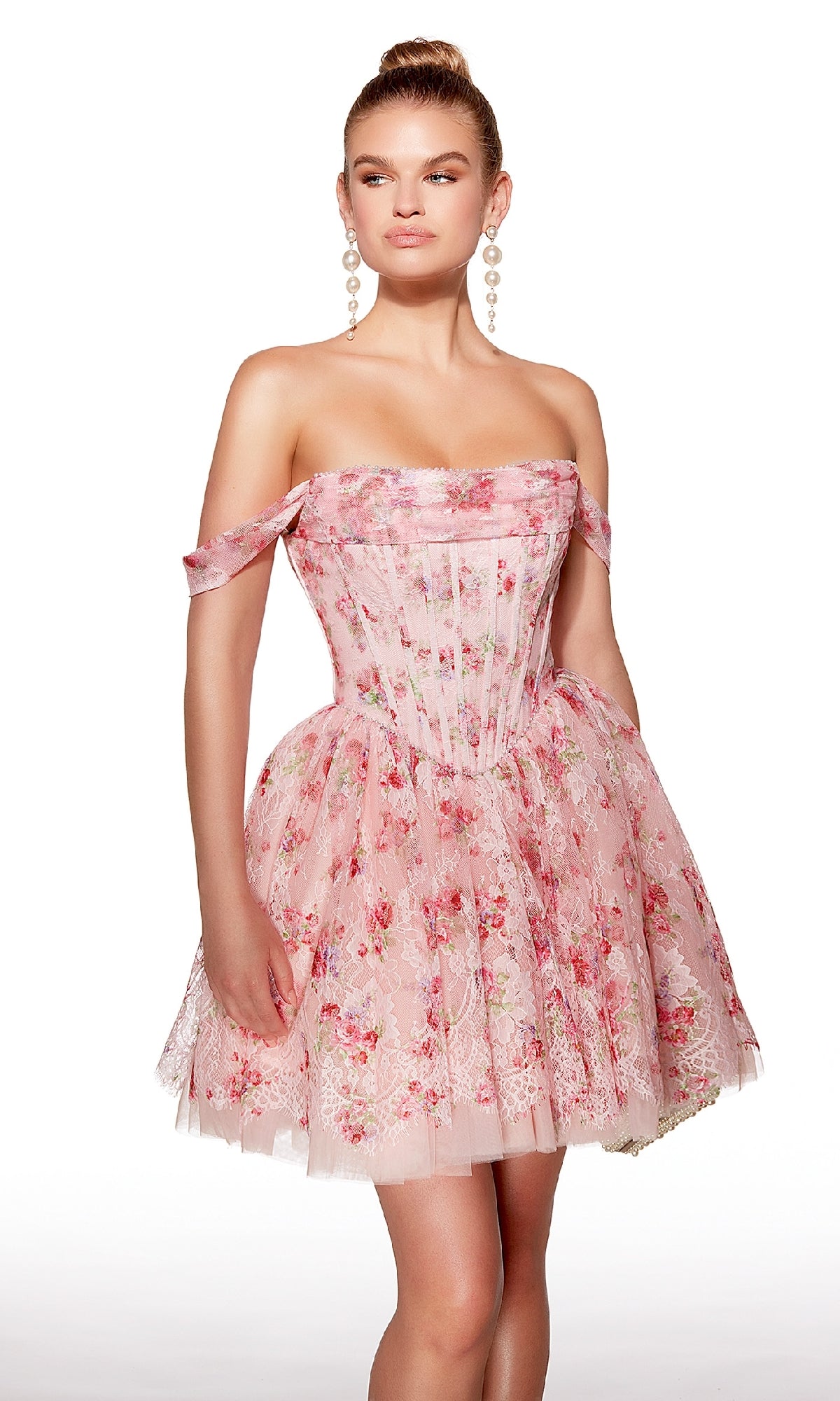 A woman models the Off-Shoulder Short Print Hoco Dress: Alyce 30021, a pink floral A-line homecoming dress with a fitted bodice and layered tulle skirt, standing against a white background.